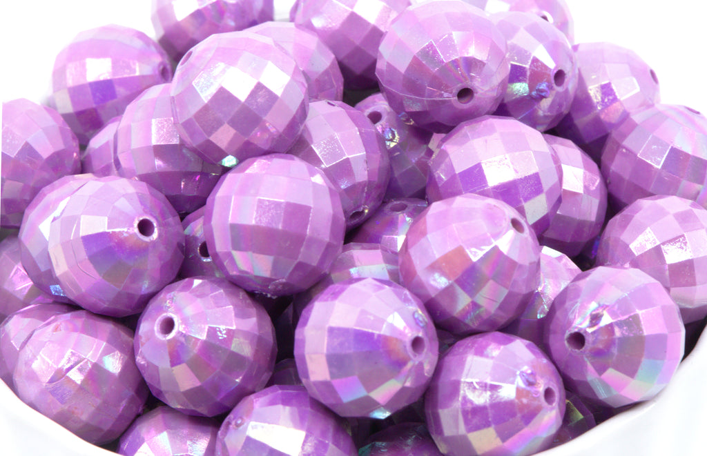 Purple faceted beads in a white bowl on a white background
