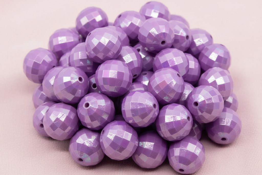 Purple faceted beads on a light pink background