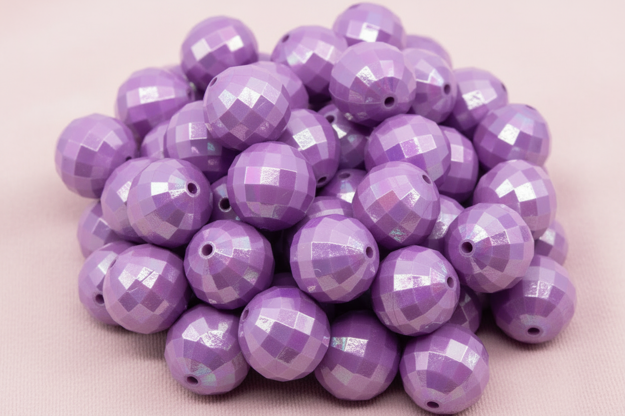 Purple faceted beads on a light pink background