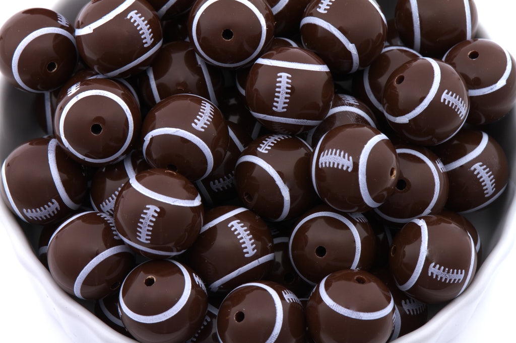 Brown and white football-shaped beads in a bowl