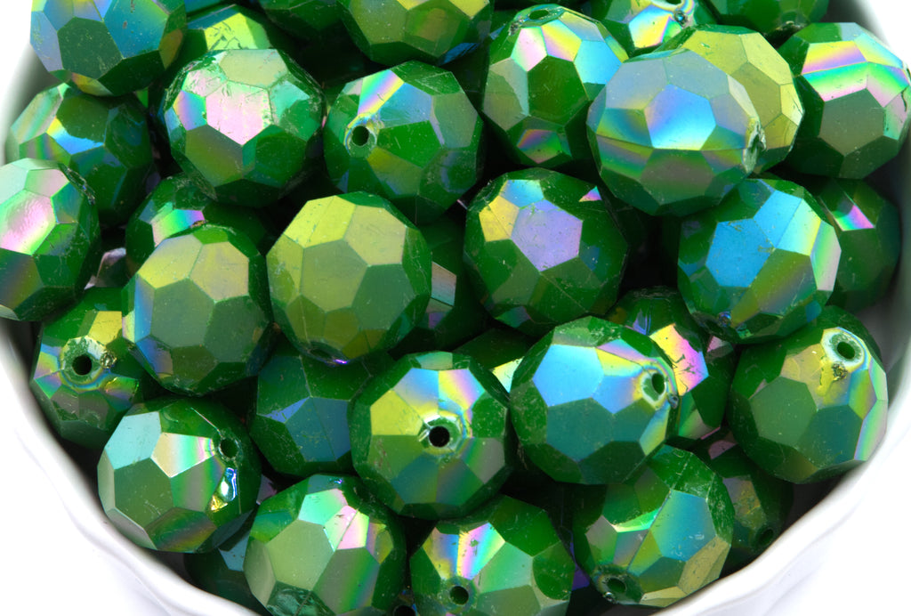 Green faceted beads in a white bowl on a white background