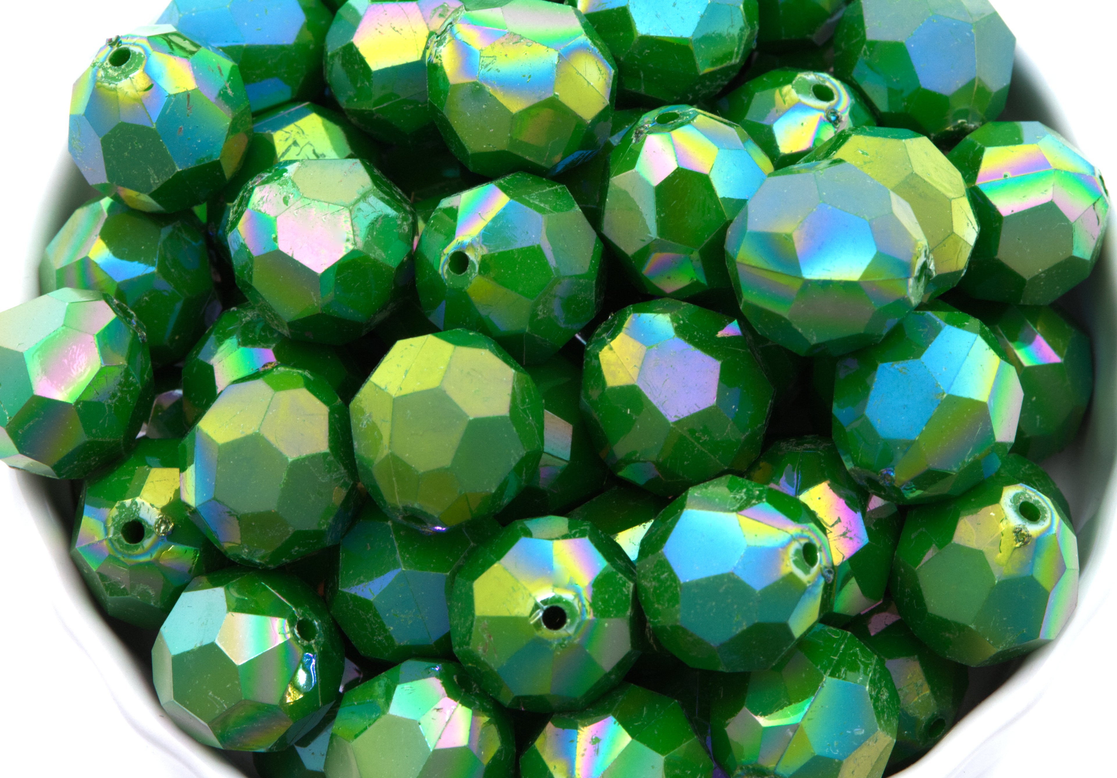 green faceted beads in a white bowl on  a white background