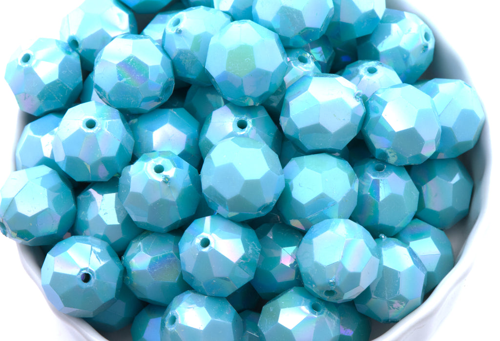 blue faceted beads in a white bowl on a white background