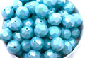blue faceted beads in a white bowl on a white background