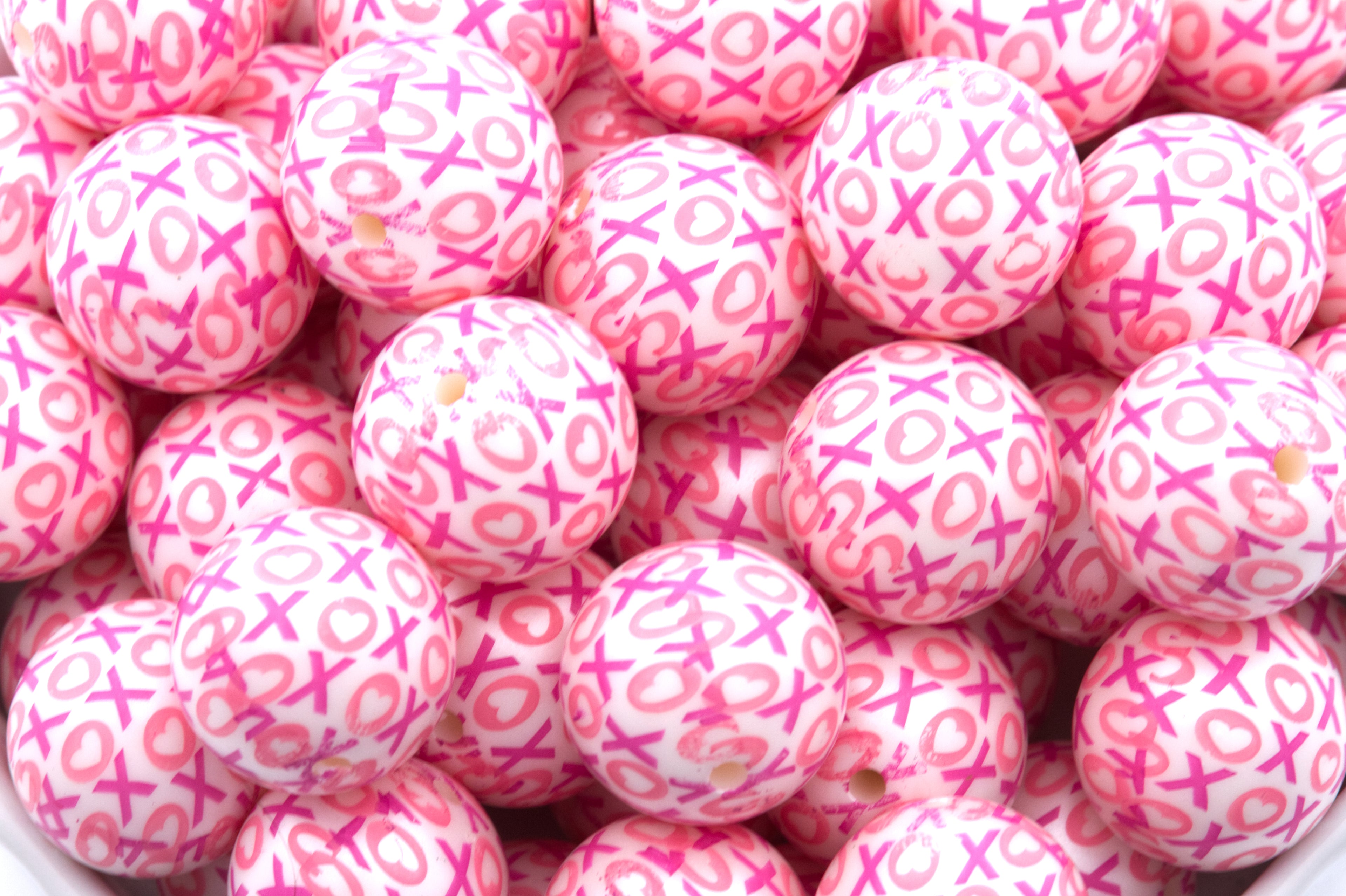 Close up of pink beads with XOXO pattern 