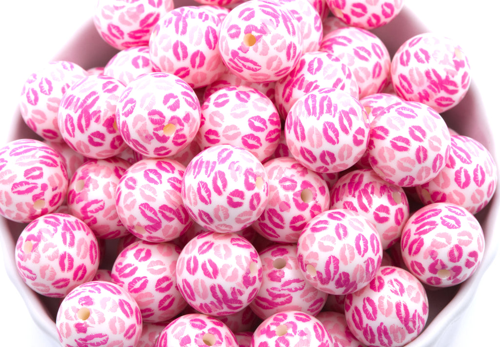 Pink bubblegum beads with kiss print pattern in a white bowl