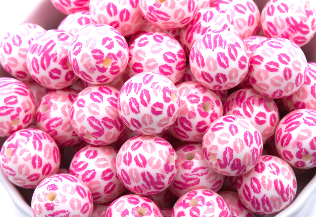 Pink bubblegum beads with kiss print pattern in a white bowl