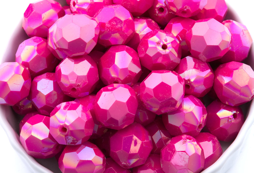 pink faceted beads in a white bowl on a white background 