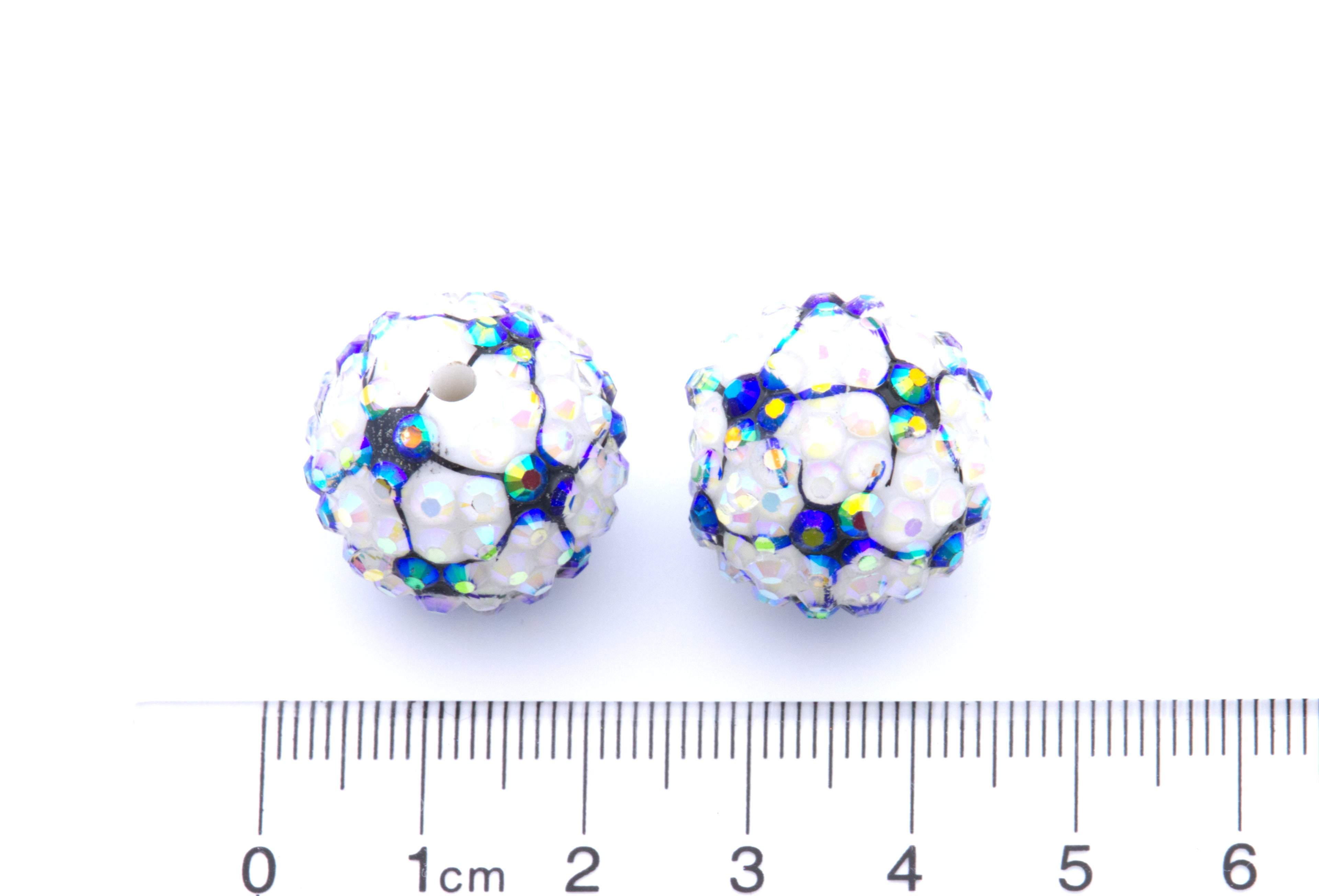 Two round soccer ball rhinestone beads shown next to a cm ruler for scale on a white background.