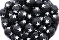 A close-up pile of  black round beads with a white star print set against a clean white background.