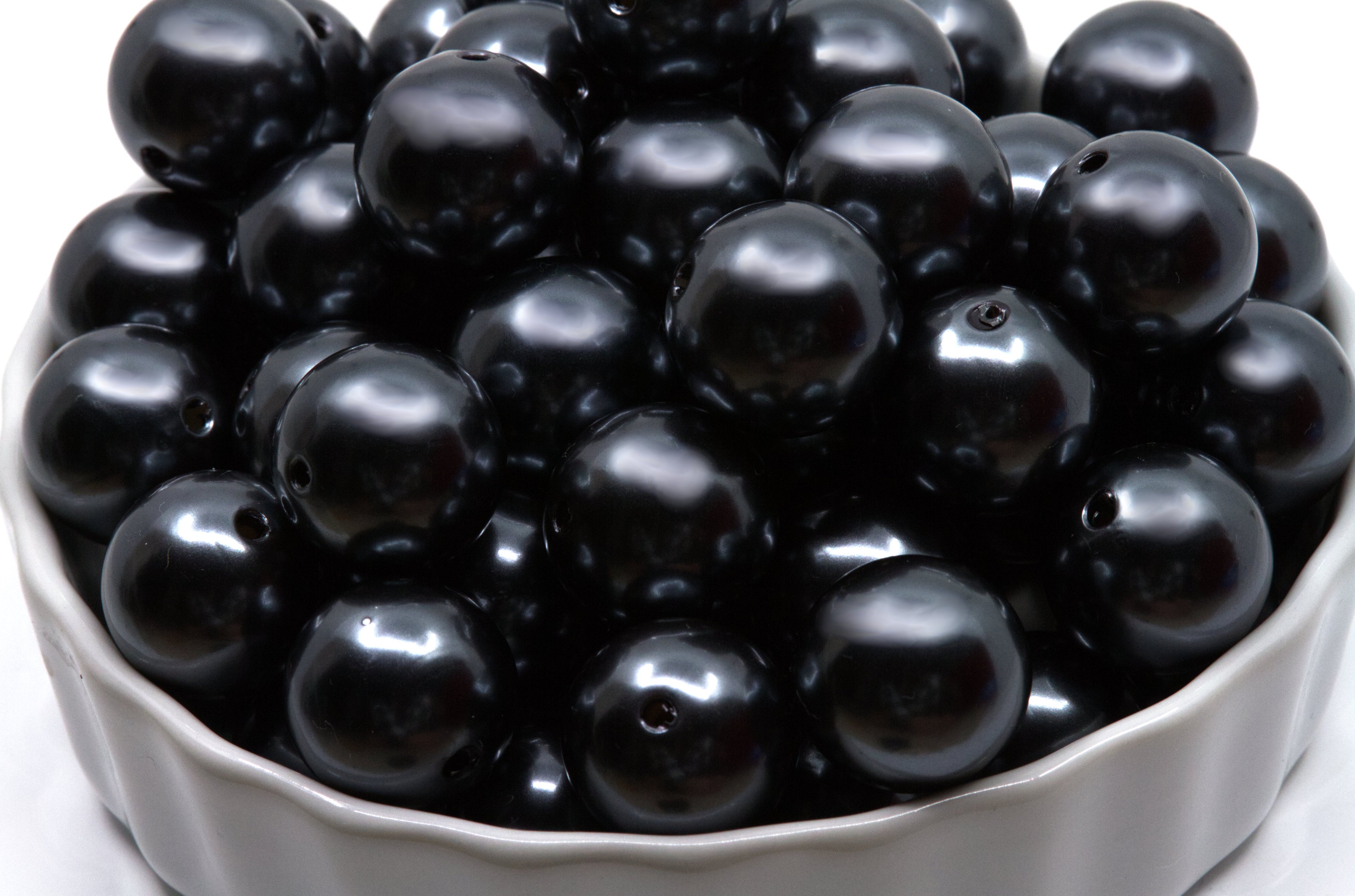 gray bubblegum beads in a white bowl on a white background 