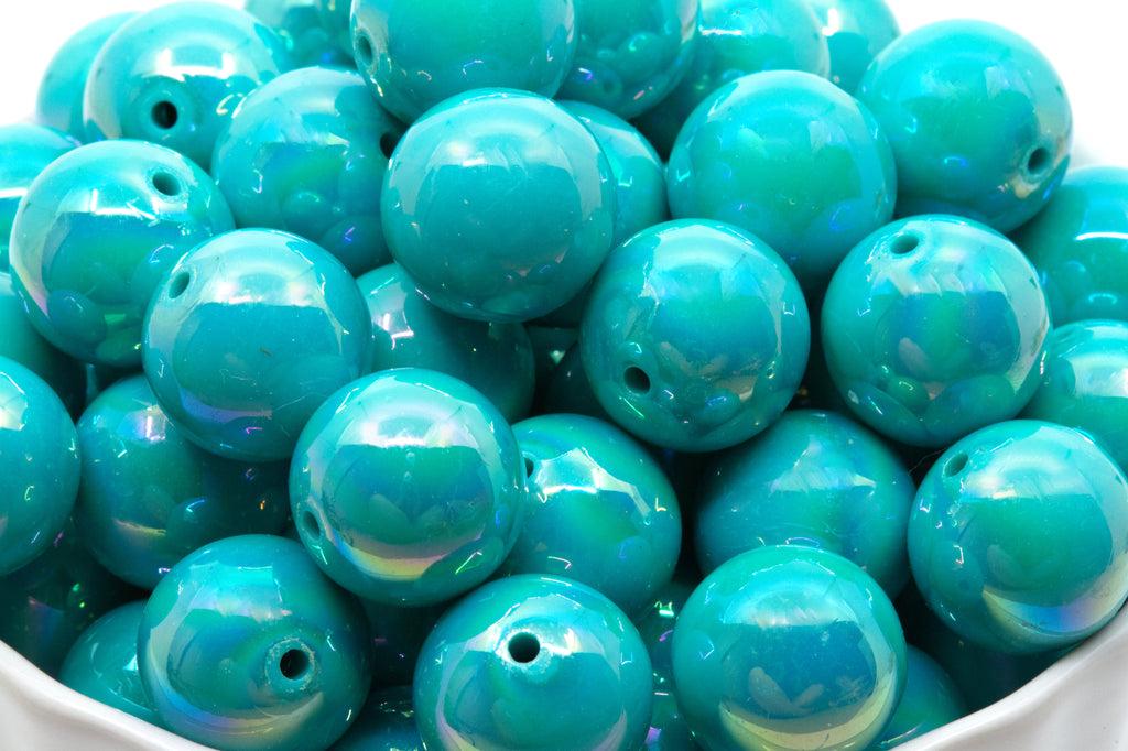 blue iridescent beads in a white bowl on a white background