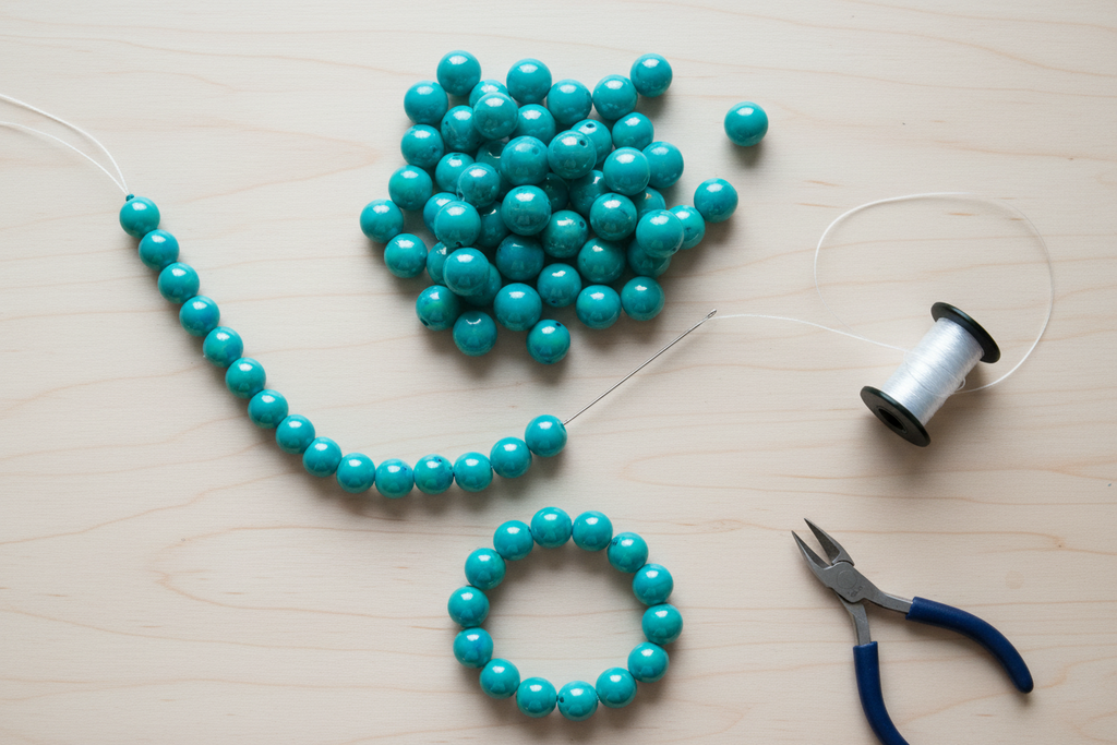blue iridescent beads shown as a bracelet with tools on a light wooden surface