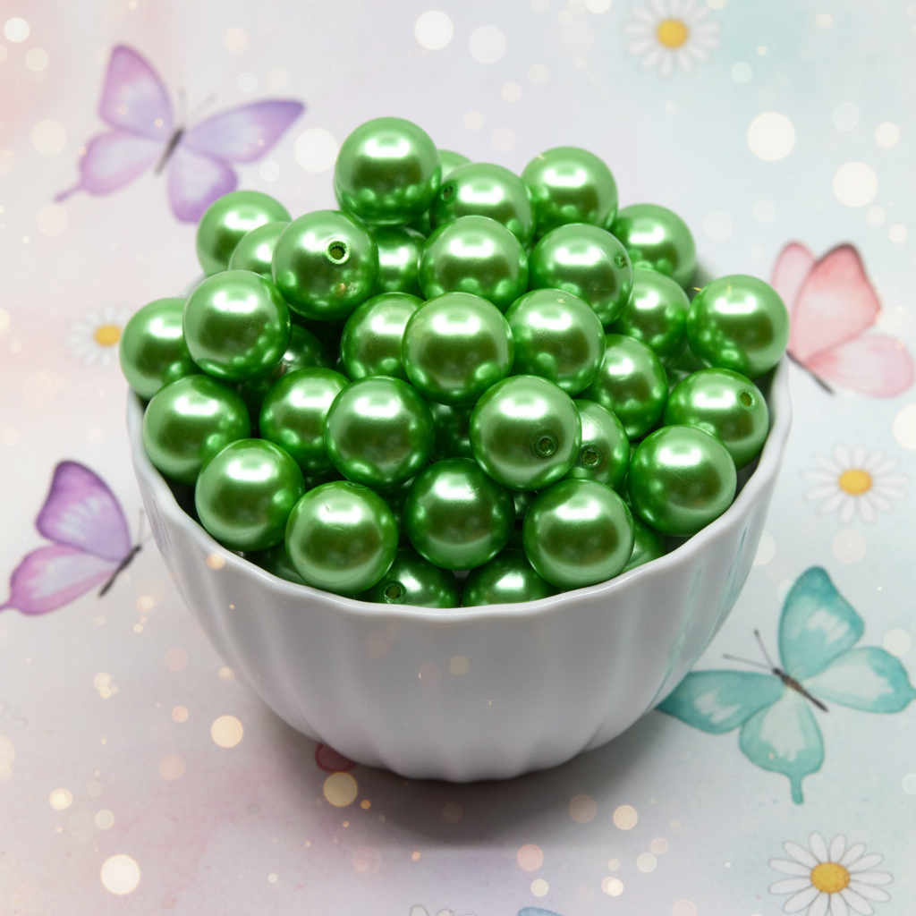 Green metallic beads in a white bowl with butterflies and flowers in the background