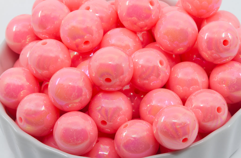 Pink iridescent beads in a white bowl