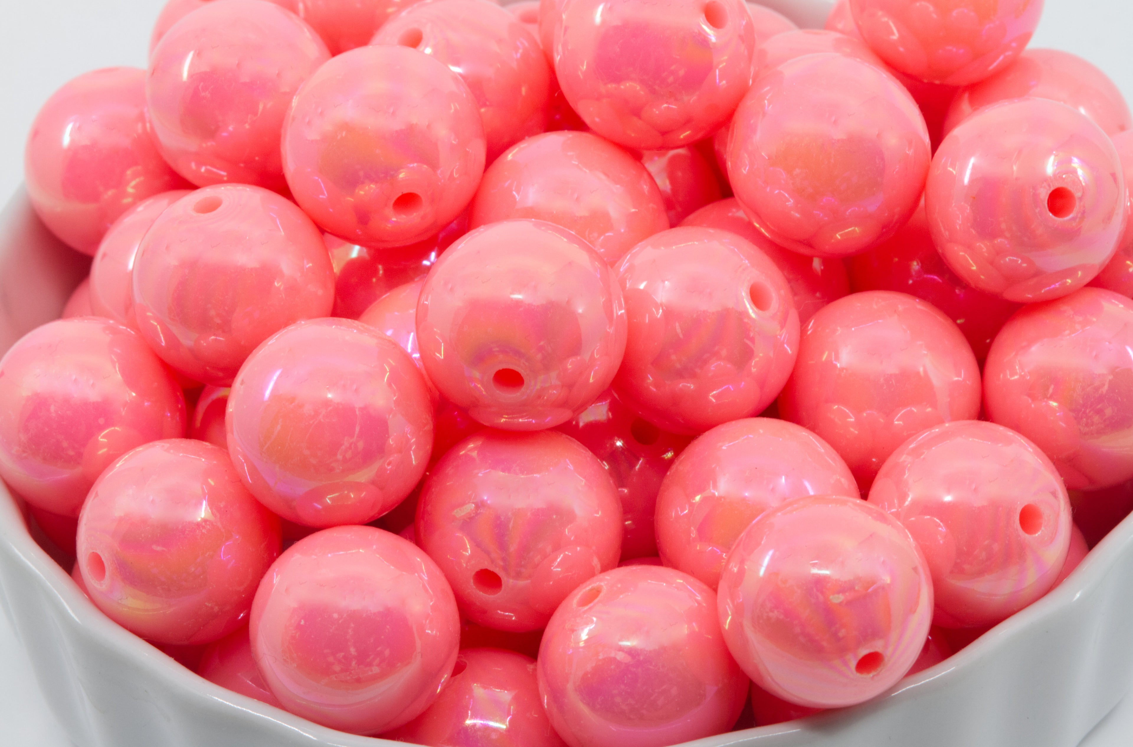 Pink iridescent beads in a white bowl