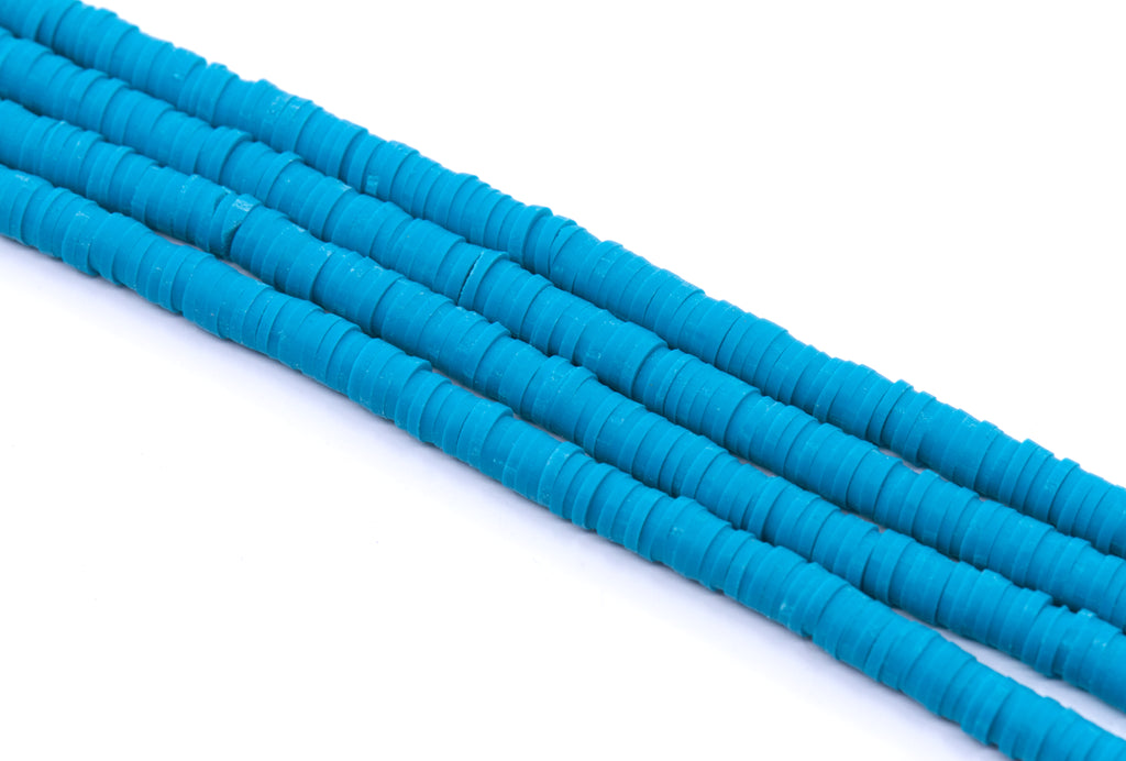multiple strands of blue polymer clay disc beads arranged diagonally on a clean white background.