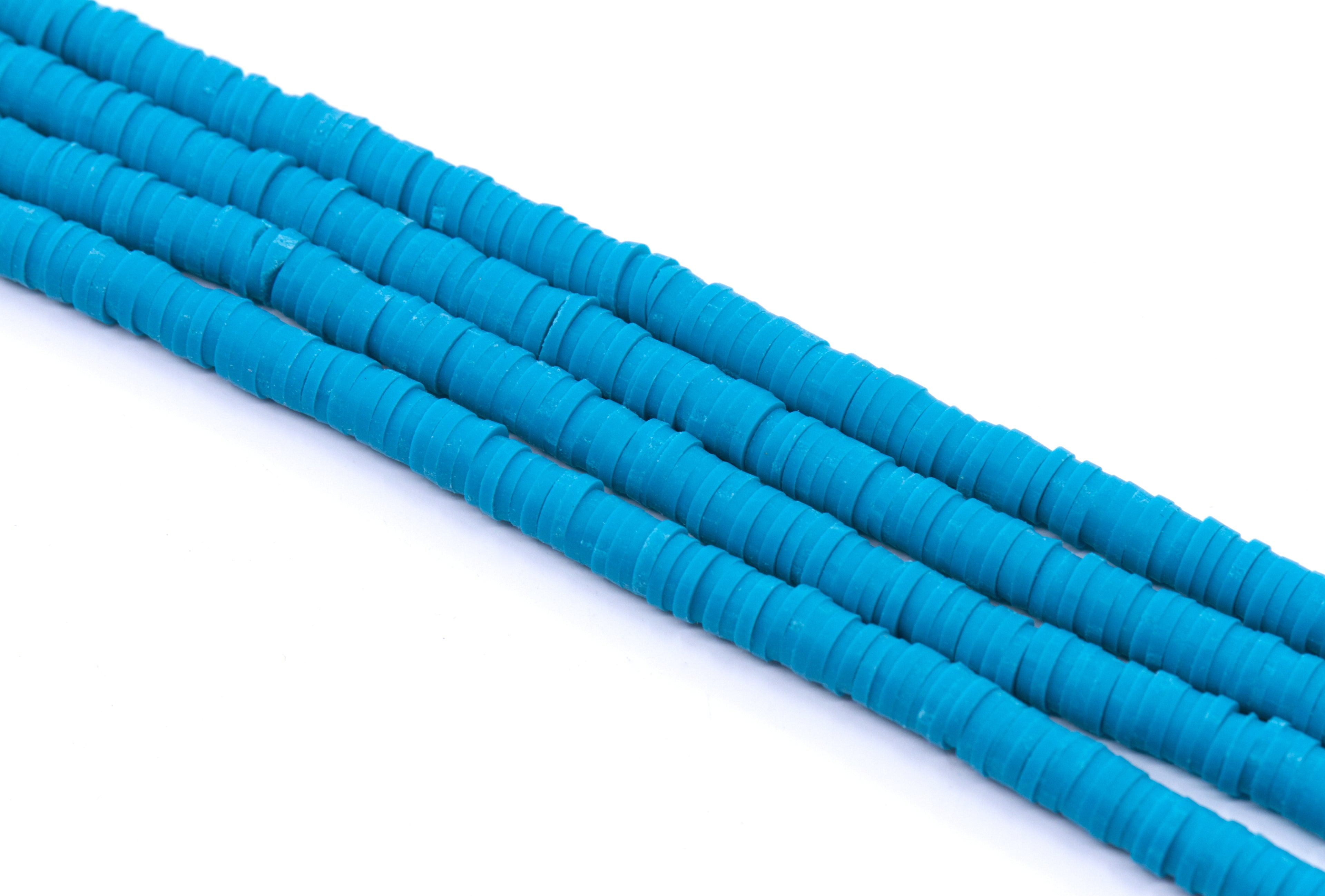 multiple strands of blue polymer clay disc beads arranged diagonally on a clean white background.
