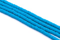 multiple strands of blue polymer clay disc beads arranged diagonally on a clean white background.