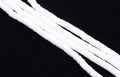 multiple strands of white polymer clay disc beads arranged diagonally on a solid black background.