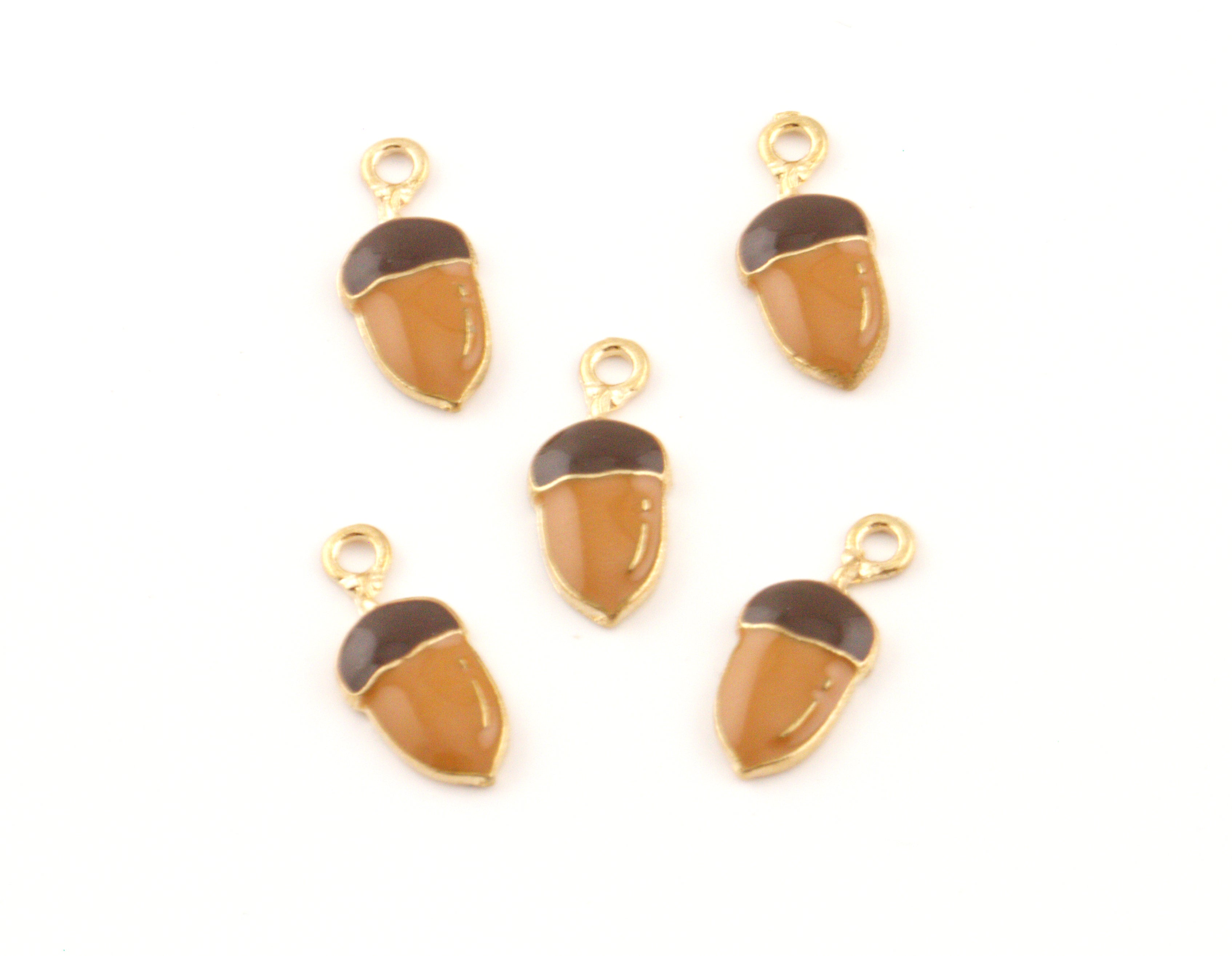 Five acorn-shaped jewelry charms with gold-tone metal frames and loops, featuring a glossy amber-brown body and a dark brown cap, arranged on a plain white background.