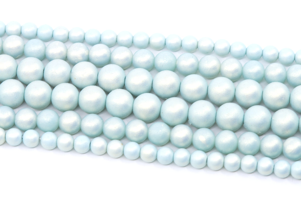 Multiple strands of light blue shimmery acrylic beads arranged diagonally on a plain white background.