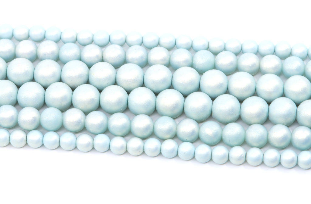 Multiple strands of light blue shimmery acrylic beads arranged diagonally on a plain white background.