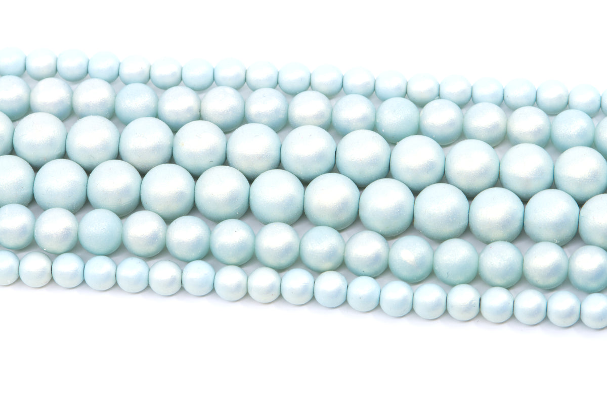 Multiple strands of light blue shimmery acrylic beads arranged diagonally on a plain white background.