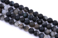 Faceted round agate beads in black and dark gray, arranged in four diagonal rows on a white background.