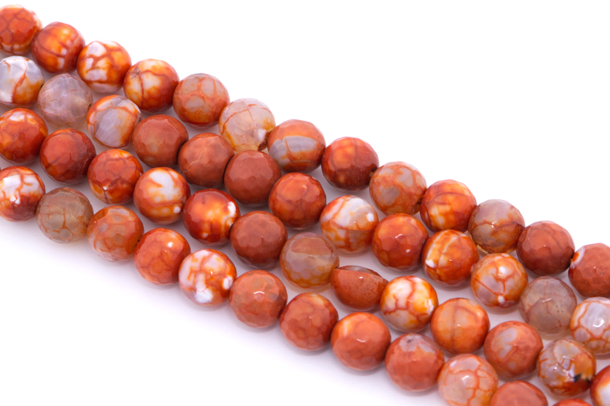 Four strands of round faceted agate beads in a mottled orange, and white agate pattern, arranged diagonally on a white background.