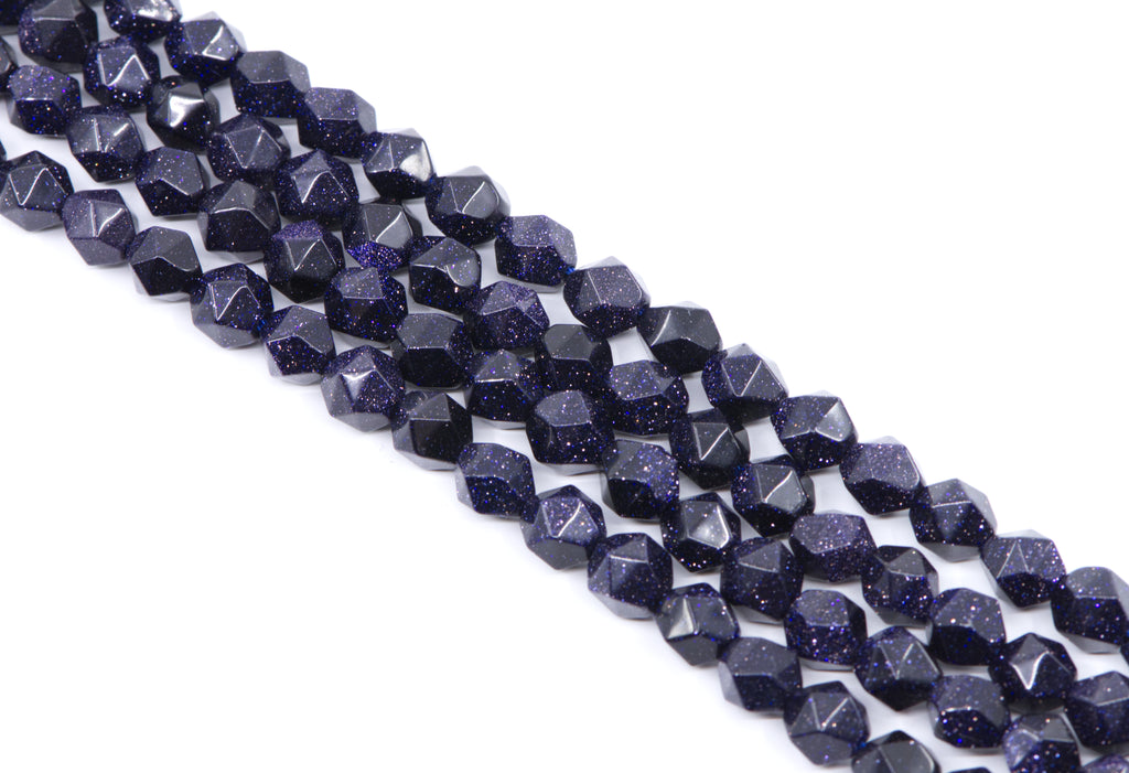 Faceted dark blue diamond cut agate beads with gold flecks, arranged in diagonal rows on a white background.