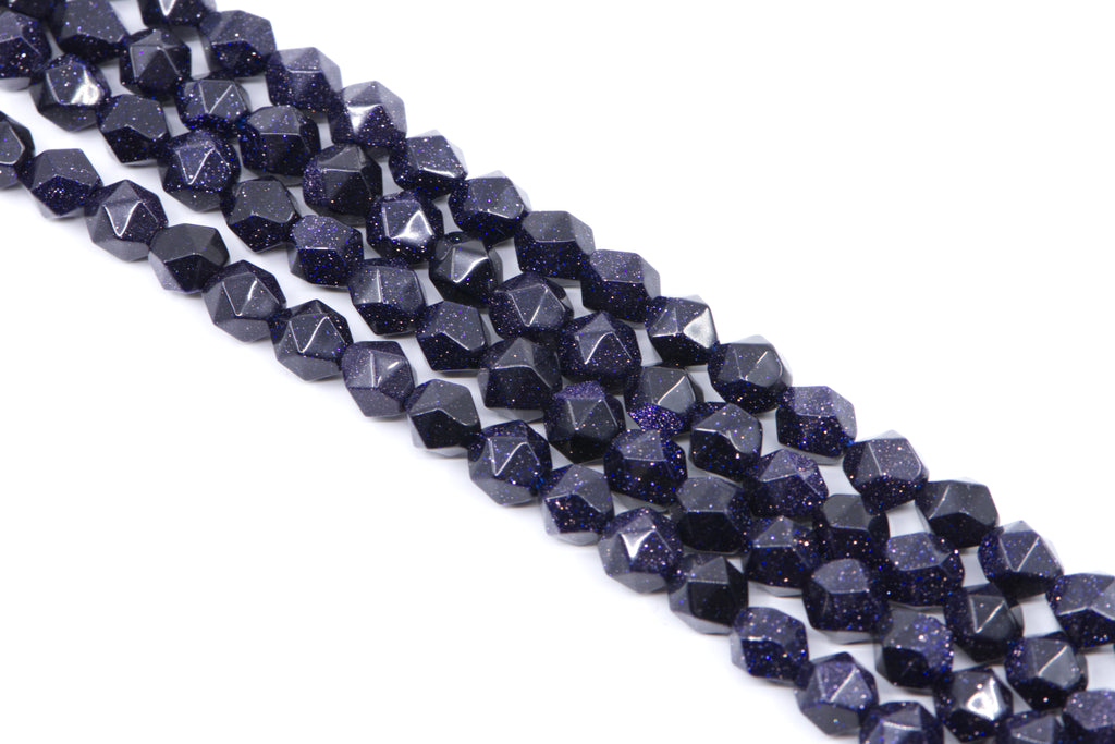 Faceted dark blue diamond cut agate beads with gold flecks, arranged in diagonal rows on a white background.