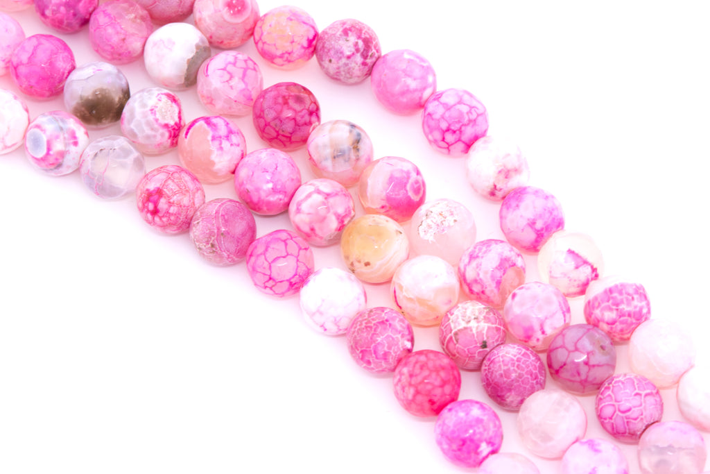 Pink faceted agate beads arranged in diagonal strands on a white background.