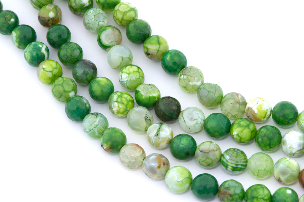 Green faceted round agate beads, arranged in four strands on a white background.