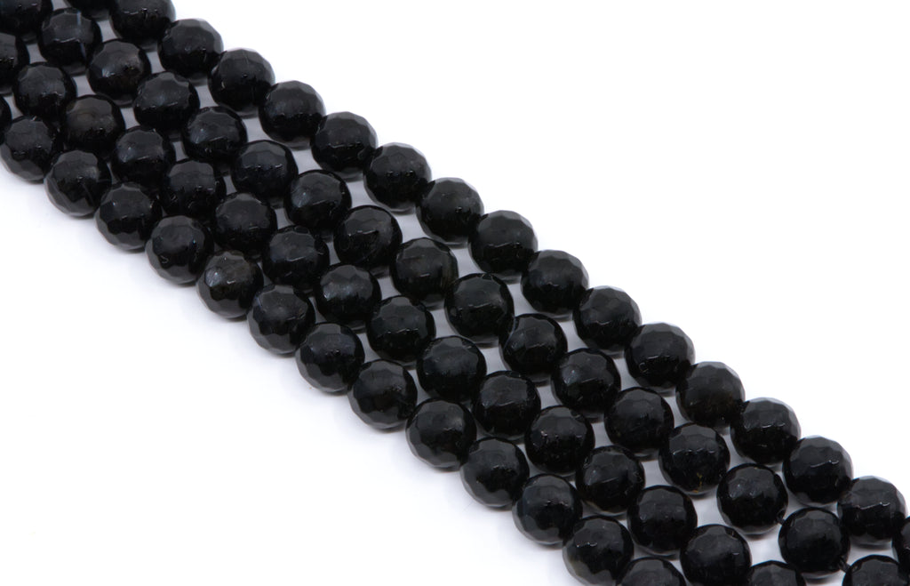  four strands of Faceted black gemstone beads strung in diagonal rows on a white background.