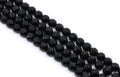  four strands of Faceted black gemstone beads strung in diagonal rows on a white background.