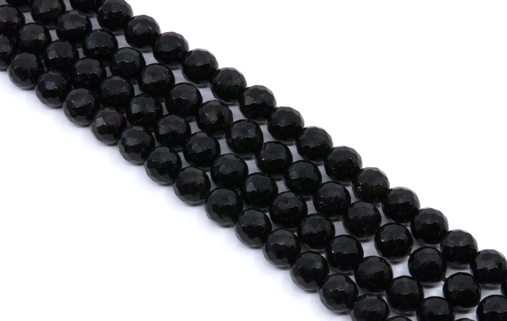  four strands of Faceted black gemstone beads strung in diagonal rows on a white background.