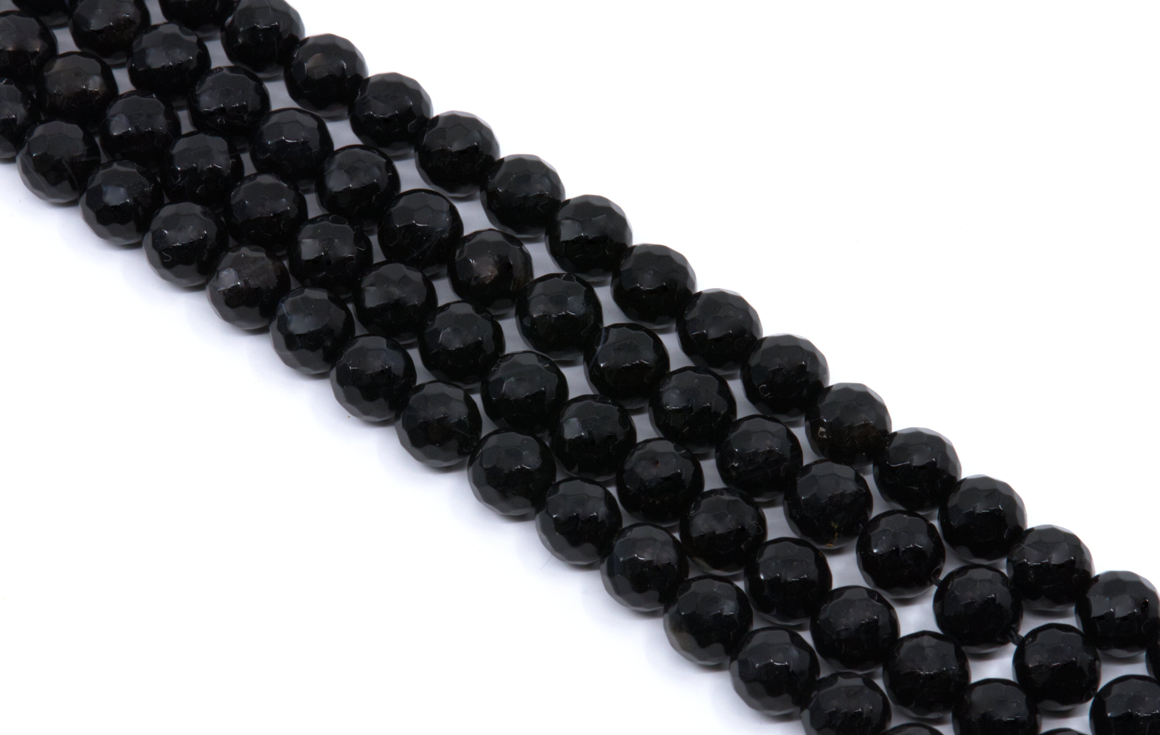  four strands of Faceted black gemstone beads strung in diagonal rows on a white background.