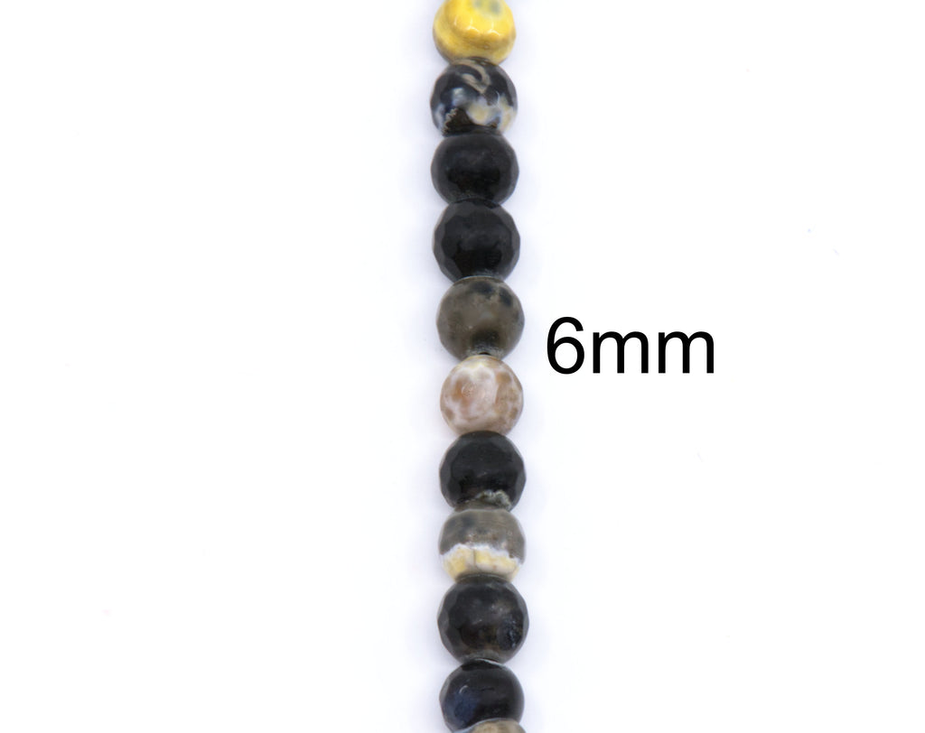 A close-up vertical strand of round polished beads in black, gray, brown, and cream tones,  and a black '6mm' size marker on the right side, shown on a plain white background.