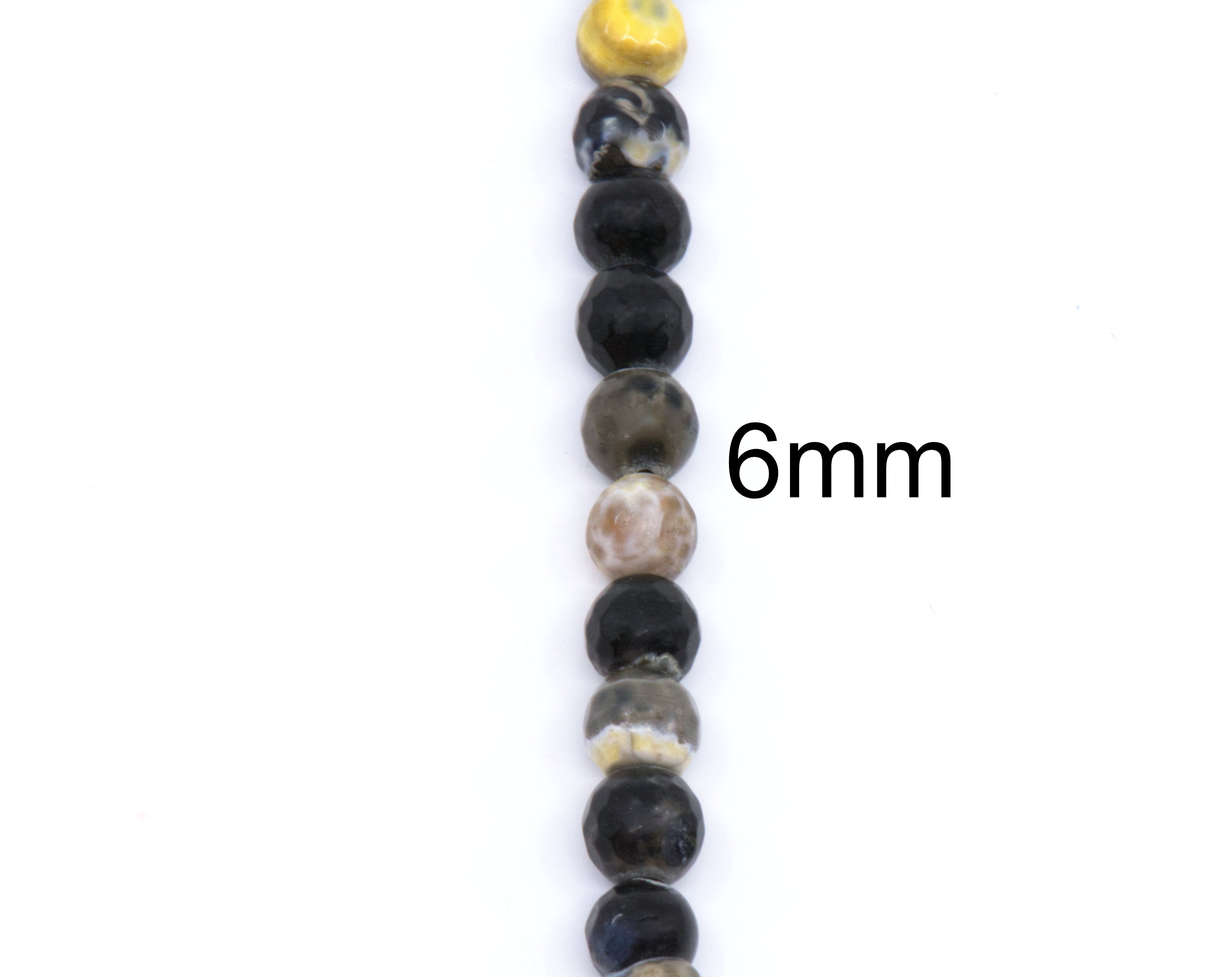 A close-up vertical strand of round polished beads in black, gray, brown, and cream tones,  and a black '6mm' size marker on the right side, shown on a plain white background.