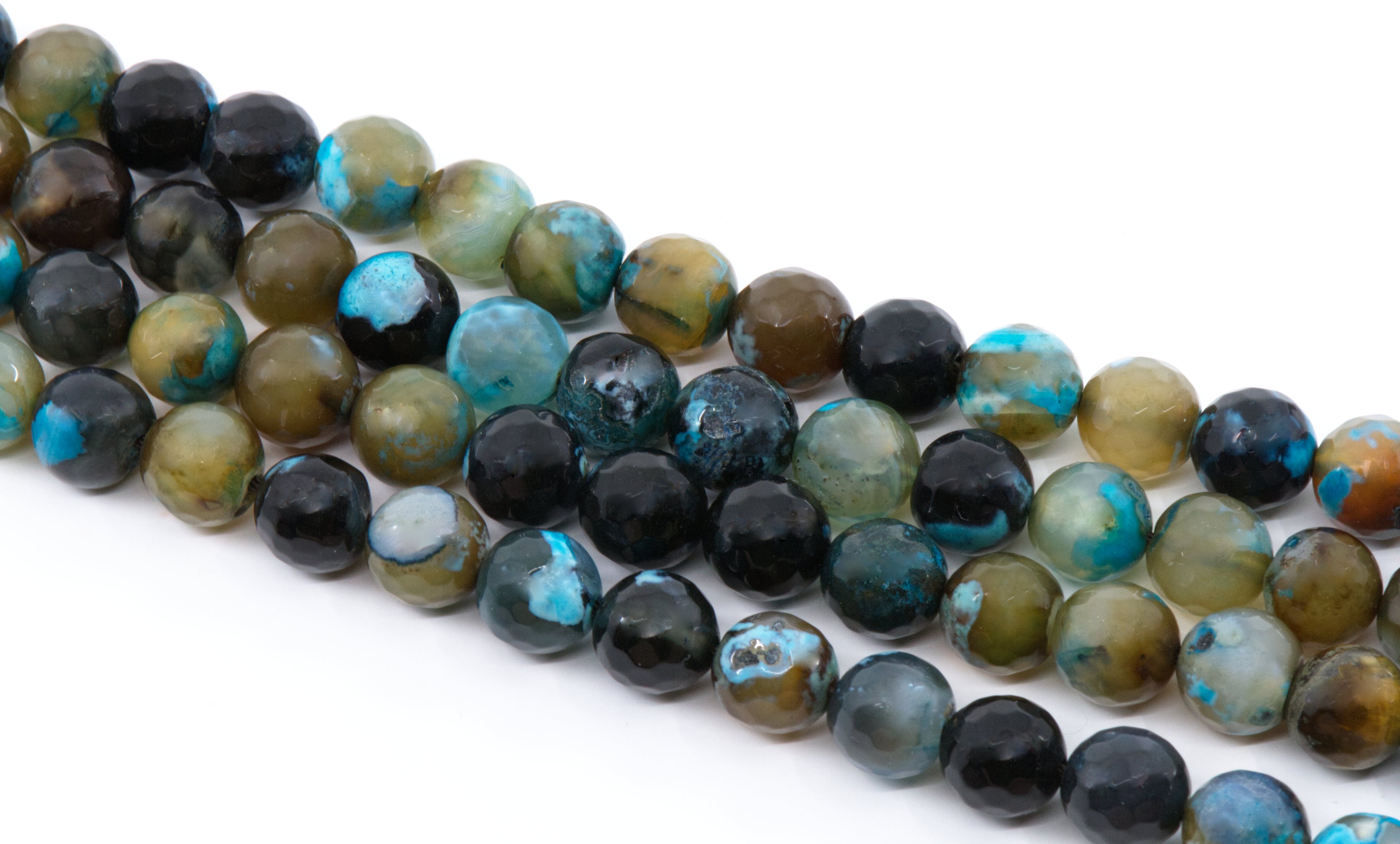 A close-up of multiple strands of polished round agate beads in black, blue,  and brown, arranged diagonally on a white background.