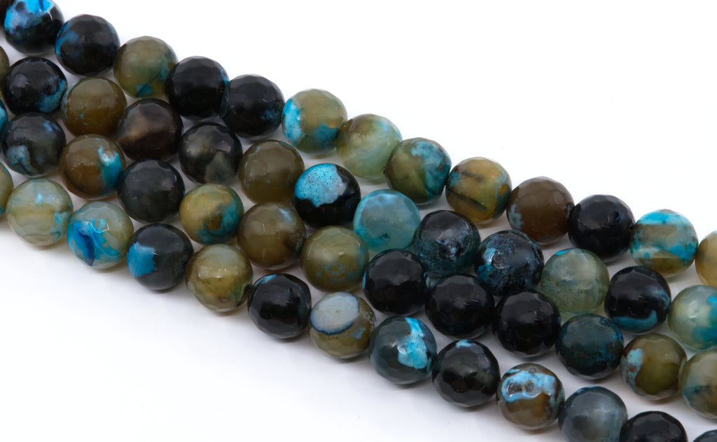 A close-up of multiple strands of polished round agate beads in black, blue,  and brown, arranged diagonally on a white background.