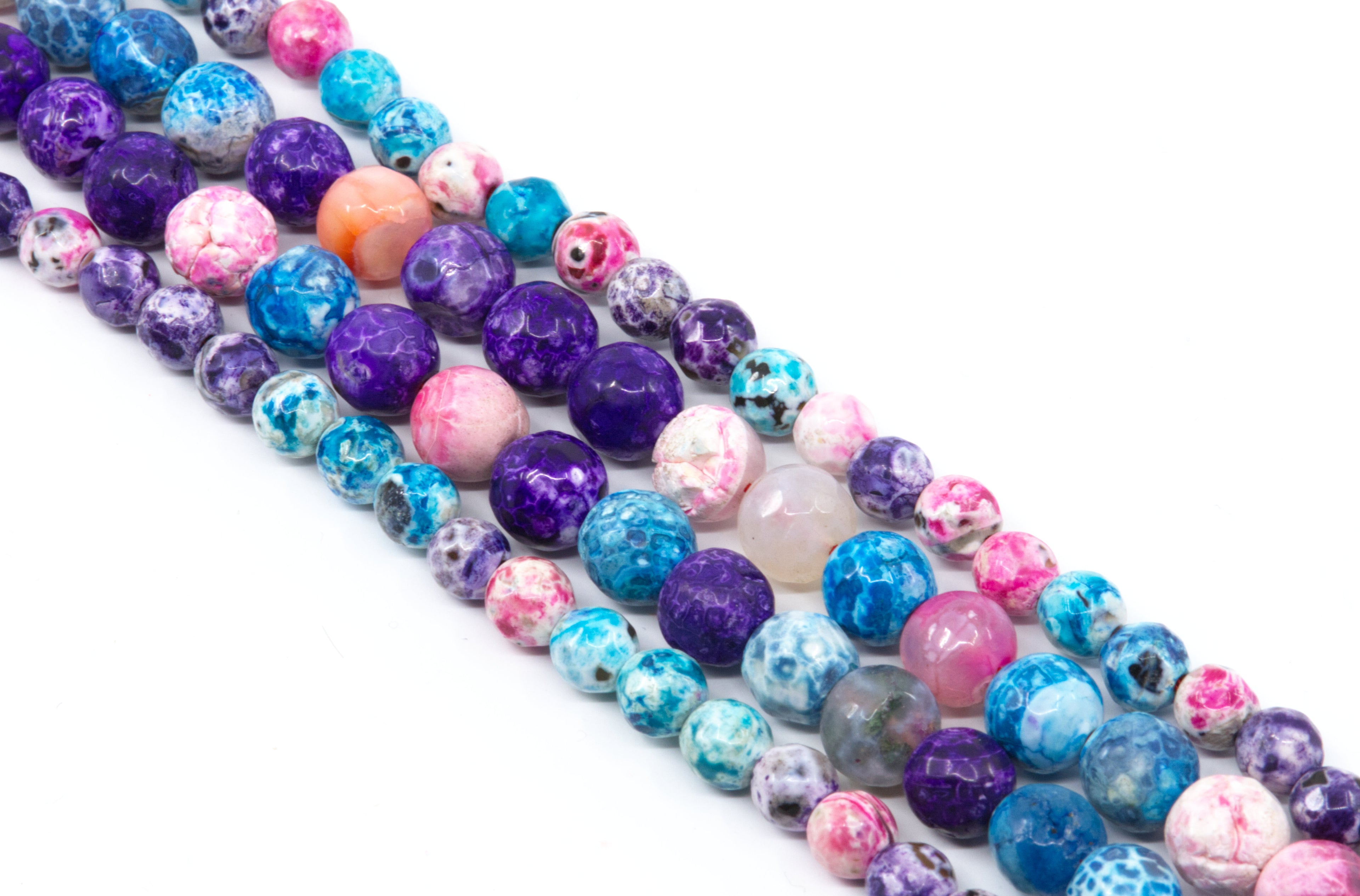 Multiple strands of round faceted agate beads in assorted colors including purple, blue, pink and white, arranged diagonally on a white background.