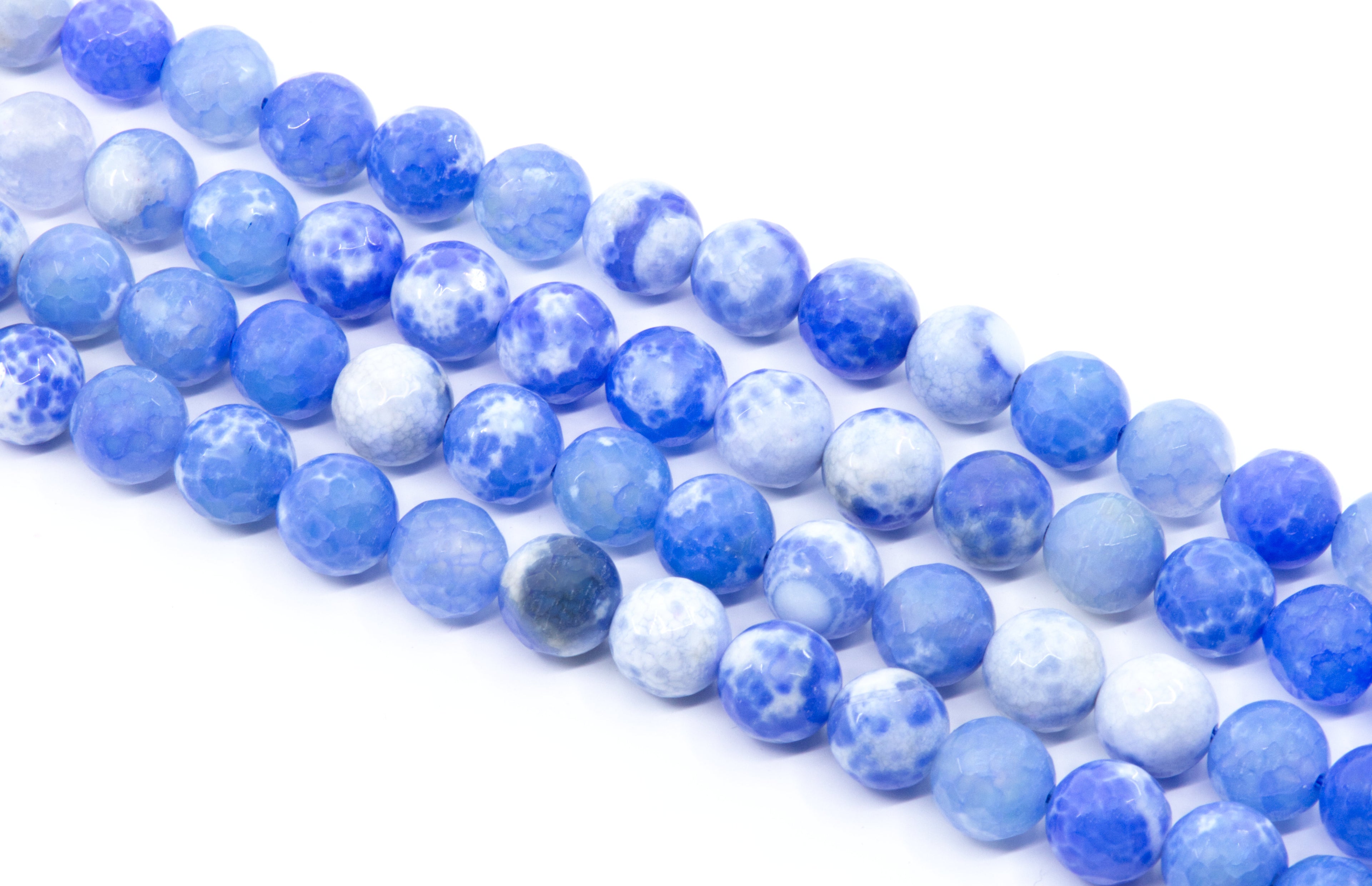 Multiple strands of round blue and white faceted agate beads arranged diagonally on a clean white background.