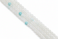 A close-up diagonal view of multiple strands of round gray beads with a few light blue marbled accent beads, photographed on a clean white background.