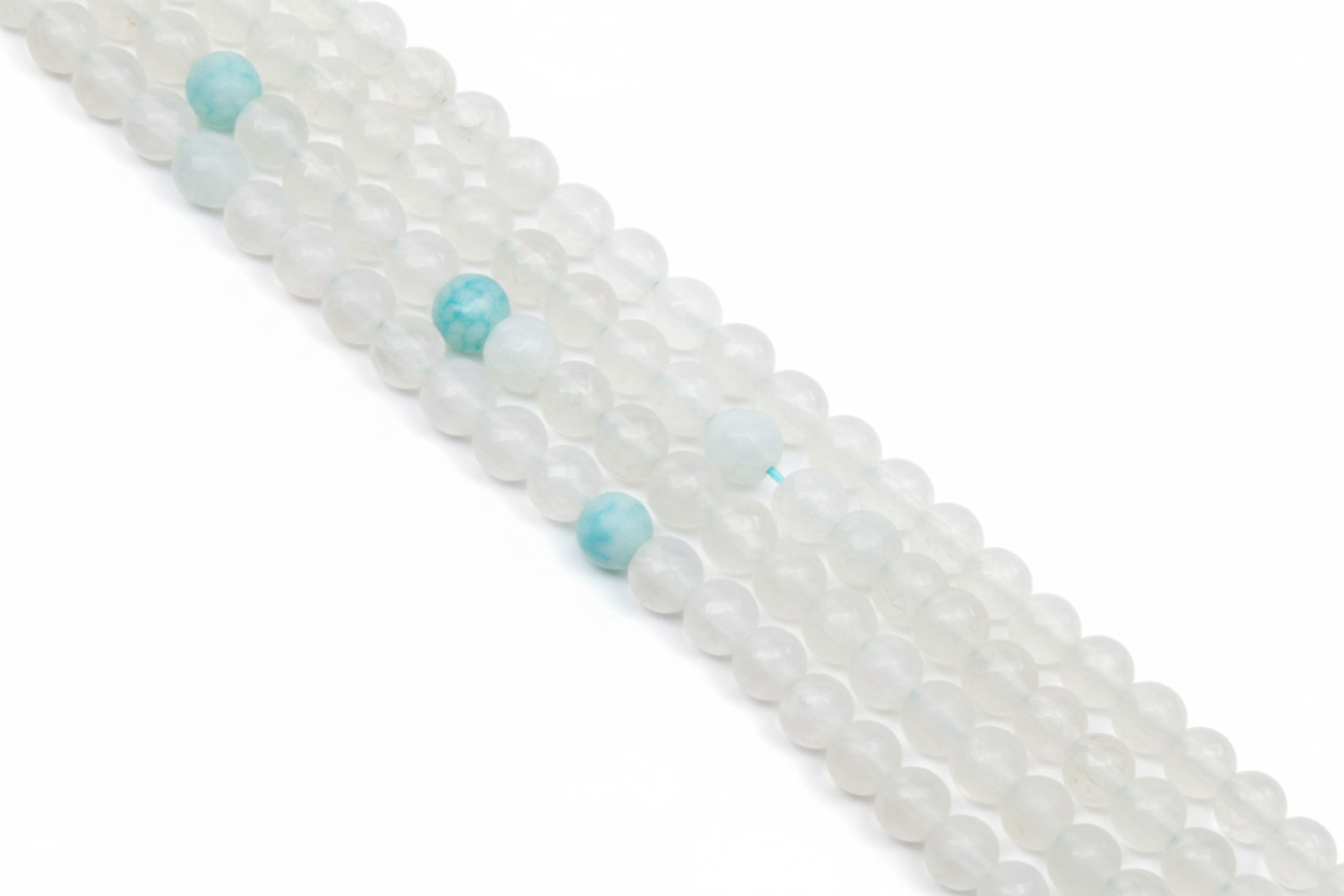 A close-up diagonal view of multiple strands of round gray beads with a few light blue marbled accent beads, photographed on a clean white background.