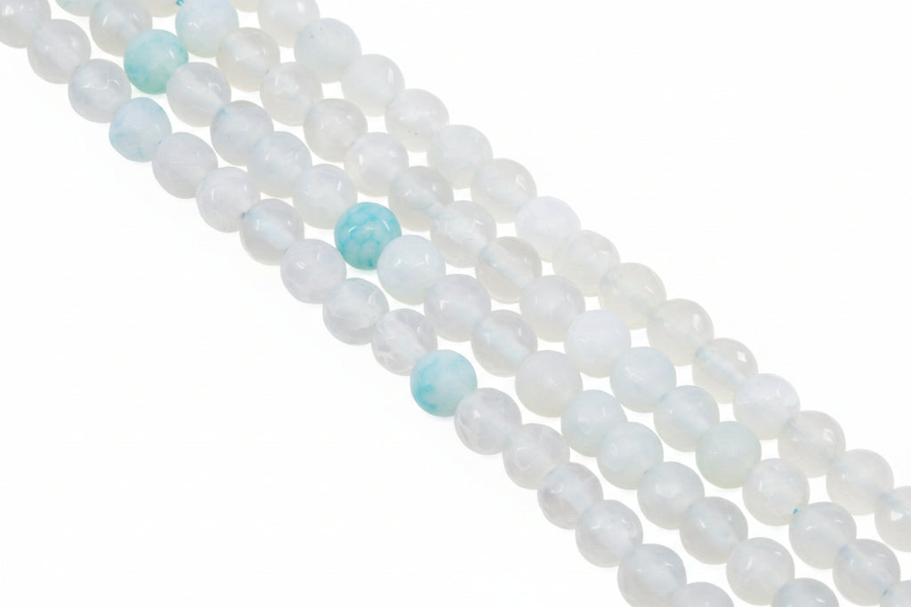 A close-up diagonal view of multiple strands of round gray beads with a few light blue marbled accent beads, photographed on a clean white background.