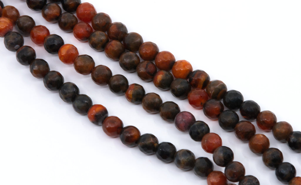 Four strands of faceted round agate beads in a mix of  orange and black with natural stone patterns, laid out diagonally on a white background.