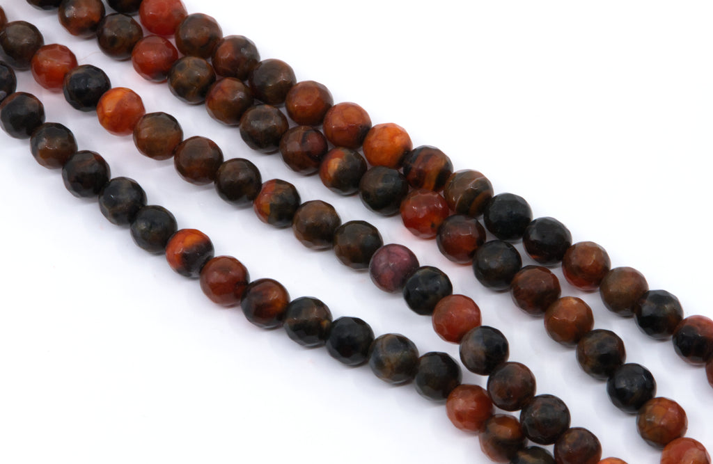 Four strands of faceted round agate beads in a mix of  orange and black with natural stone patterns, laid out diagonally on a white background.