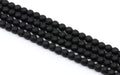 Faceted black round agate beads arranged in four parallel strands on a plain white background.